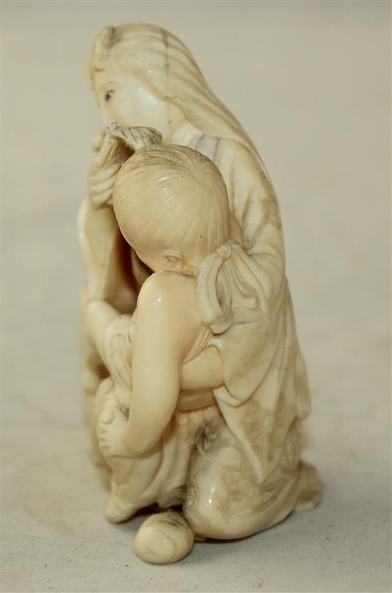 A Japanese ivory okimono of a mother suckling a child, Meiji period, 7.7cm